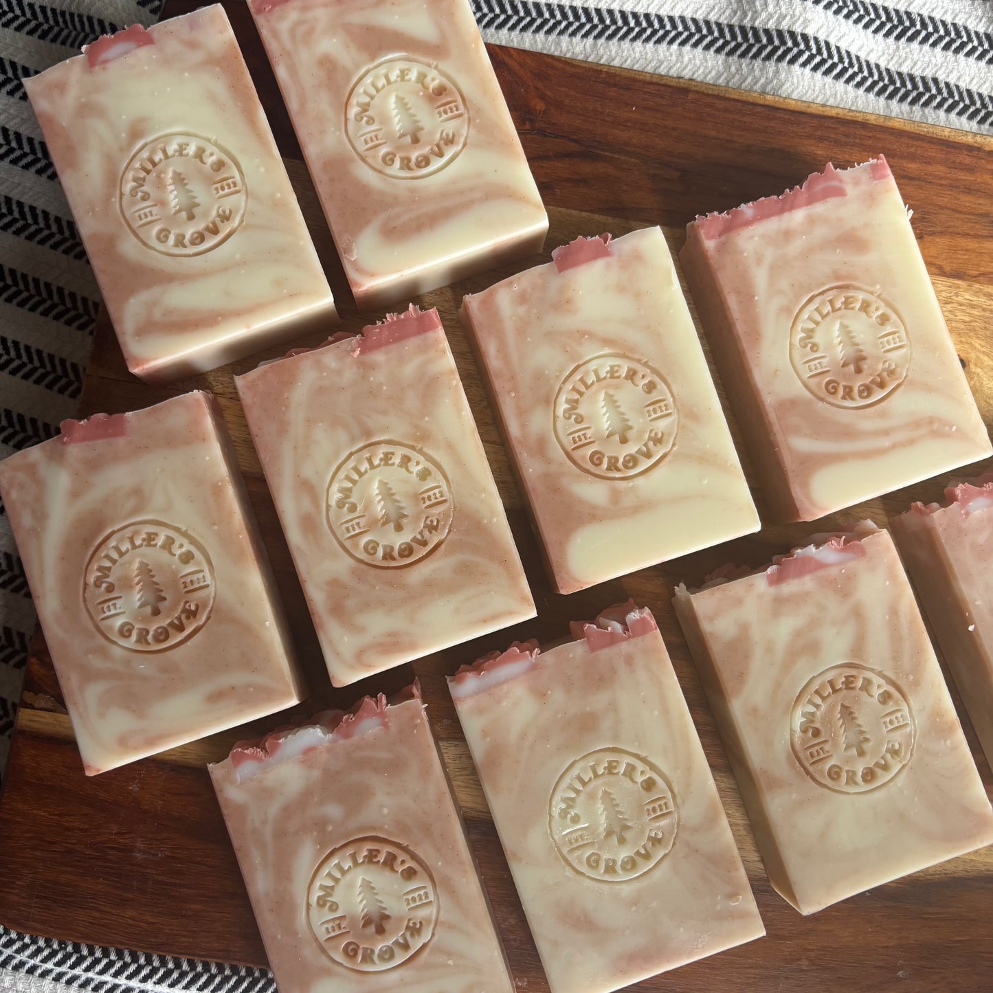Multiple bars of soap with a visible brand logo on a wooden surface.