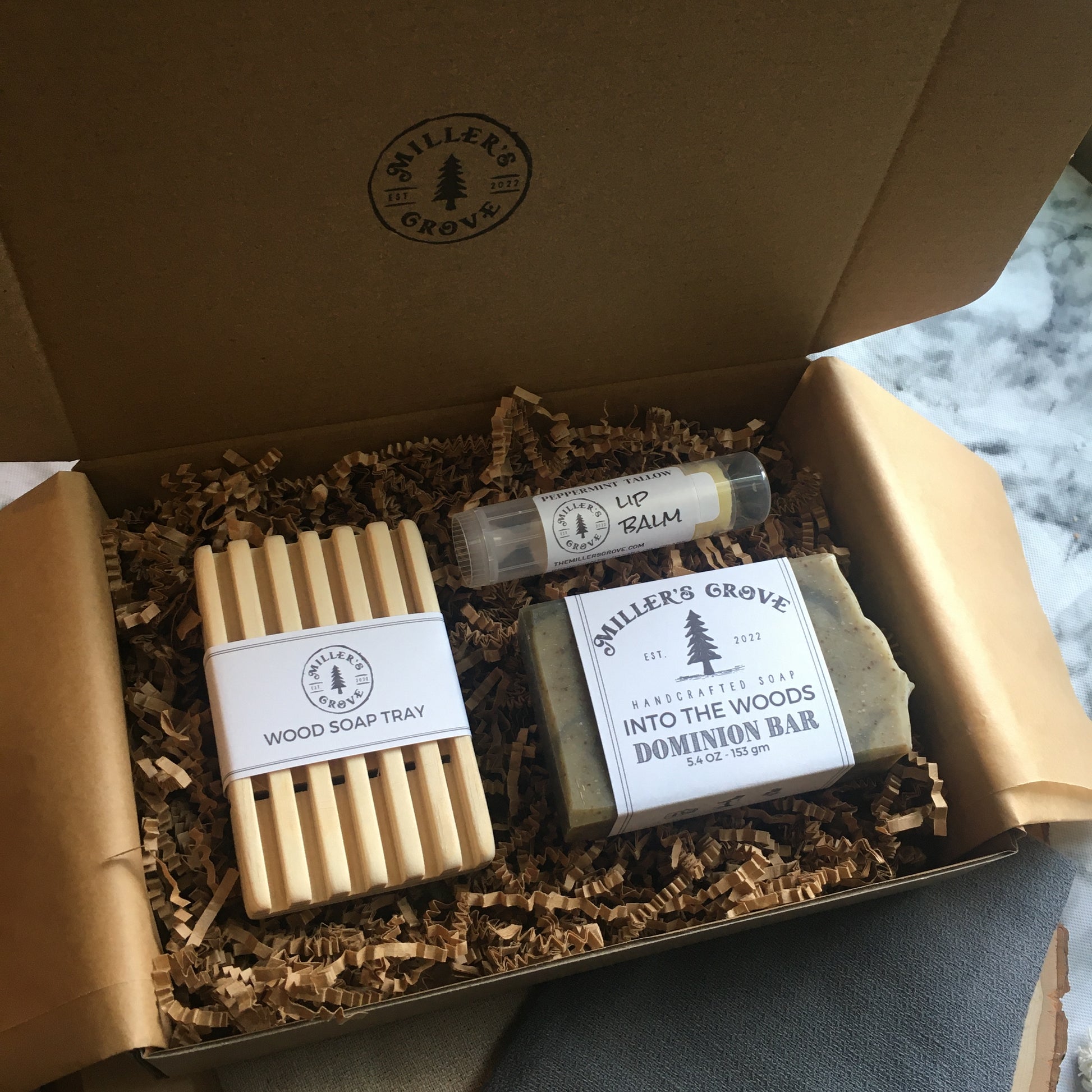 example of items in a brown cardboard gift box and brown crinkle paper