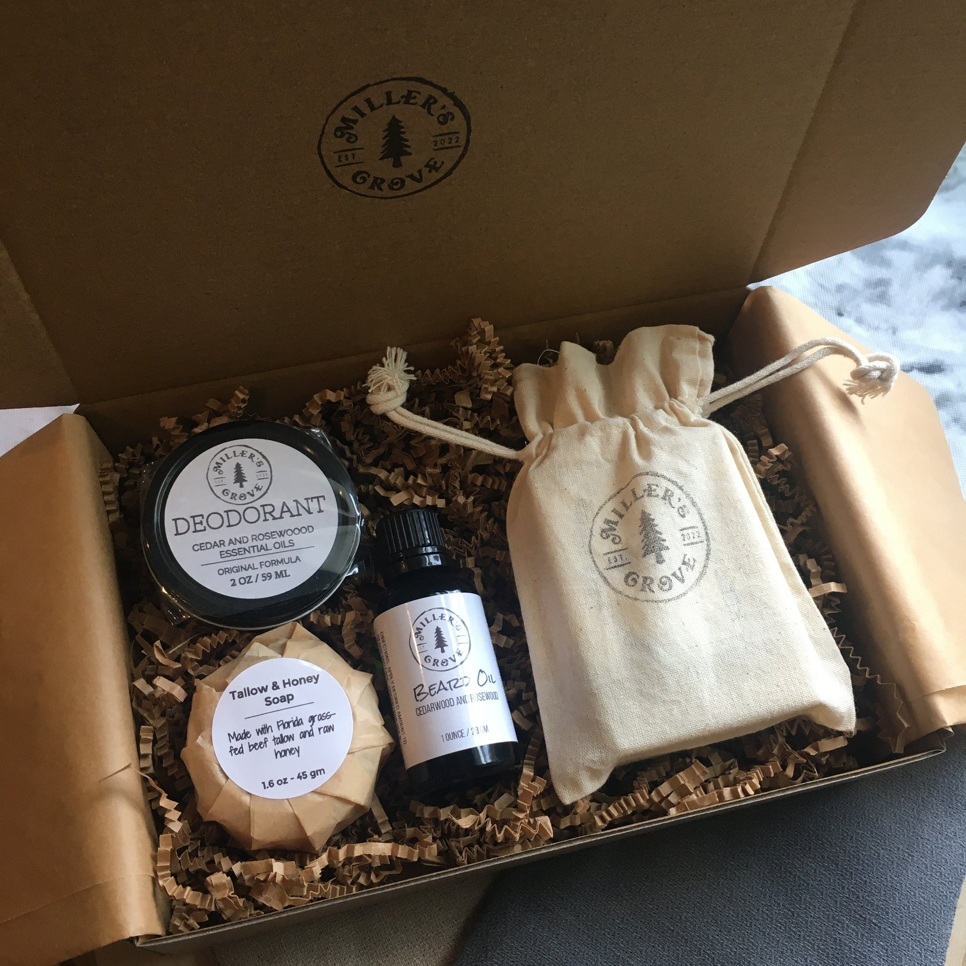 example of items in a brown cardboard gift box with brown crinkle paper