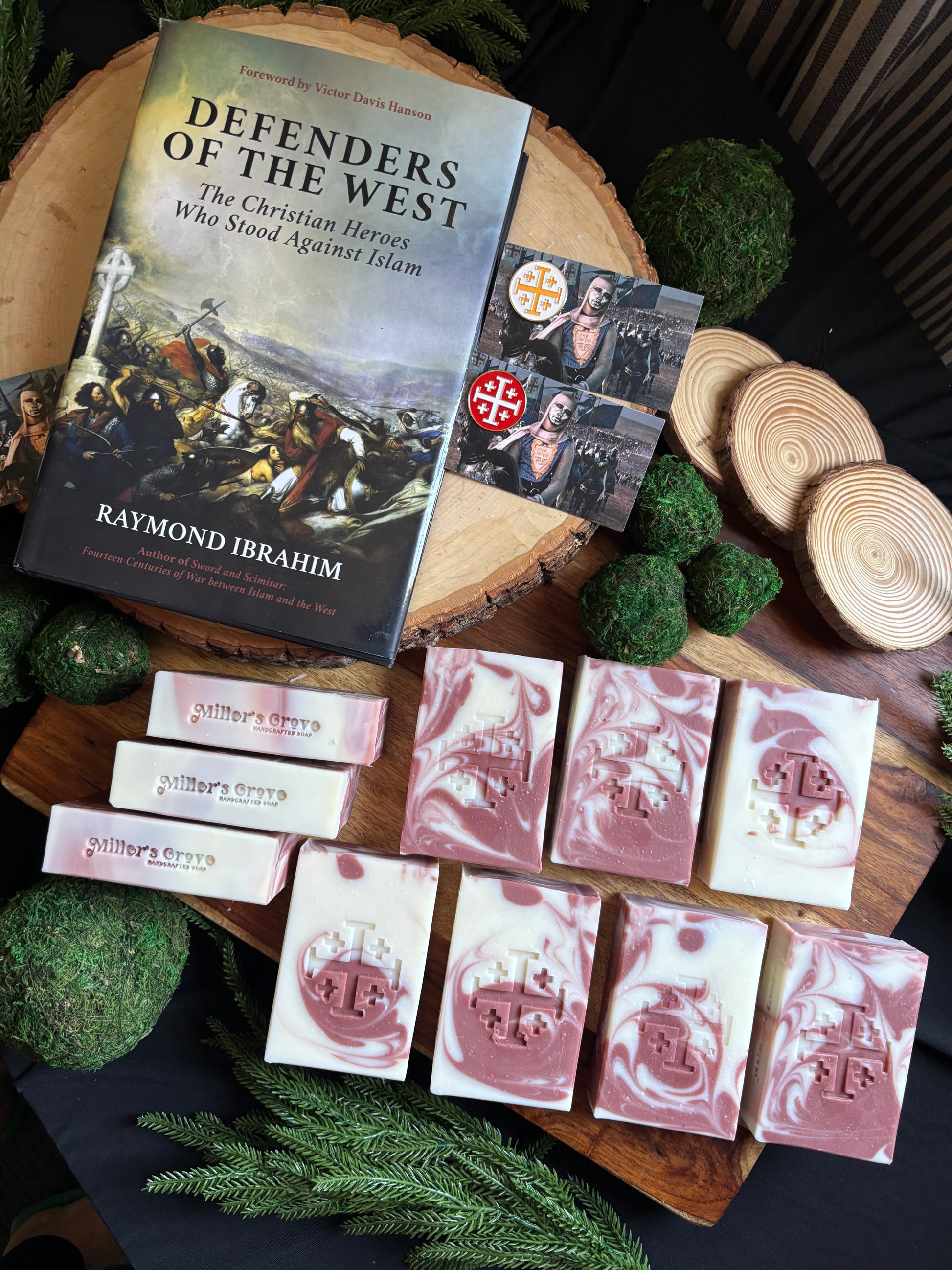Wooden tray with soap bars and a book titled 'Defenders of the West' on a dark background