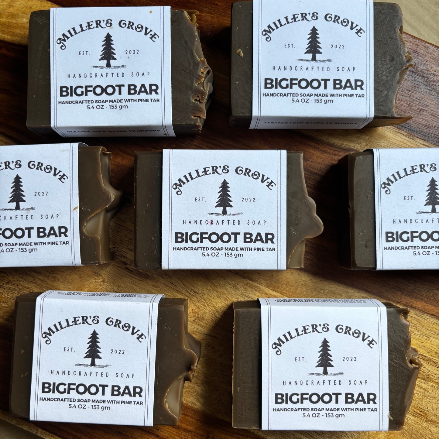 Multiple bars of soap with 'Miller's Grove' labels on a wooden surface