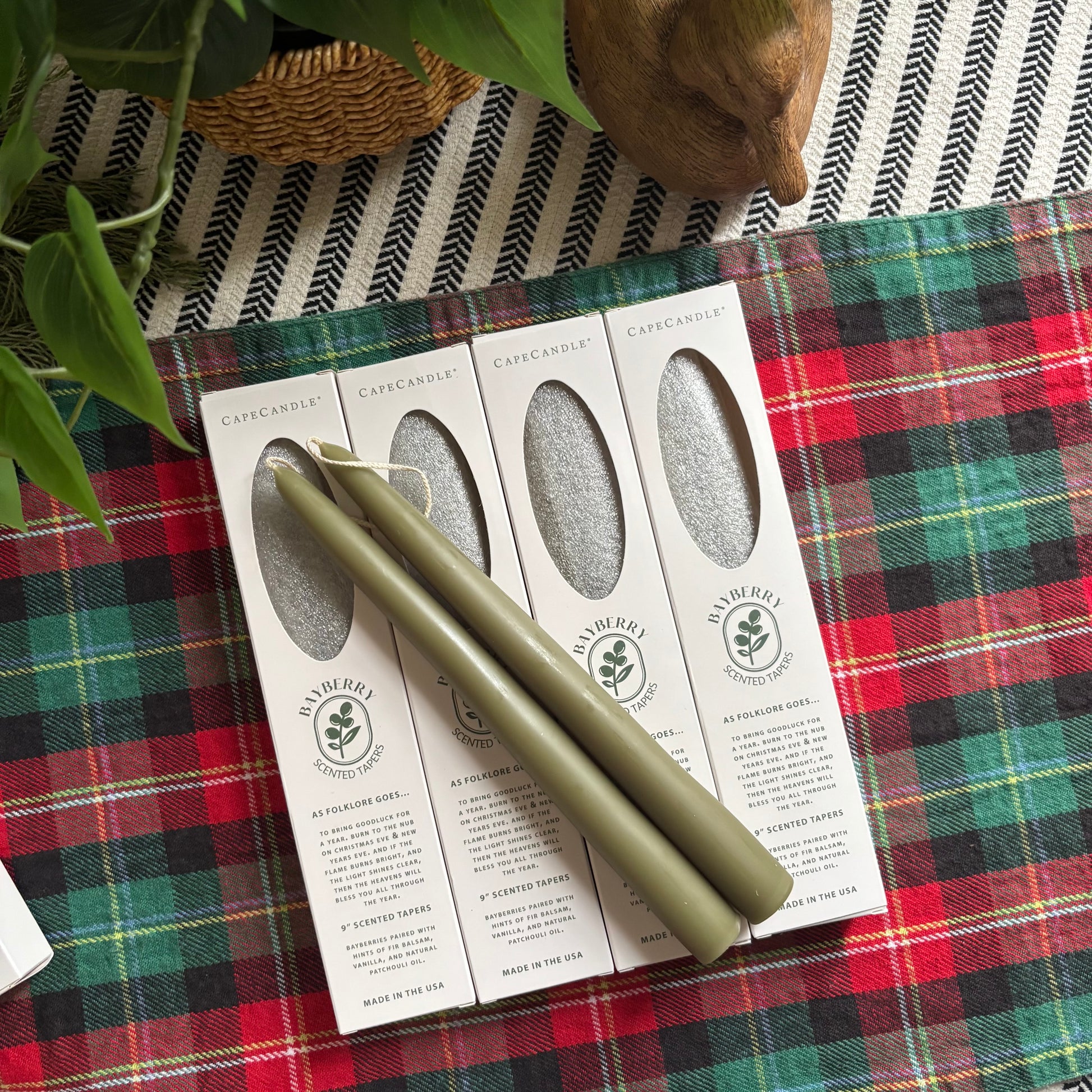 Green rolling pin on a box with 'CapeCandle' branding on a plaid tablecloth.