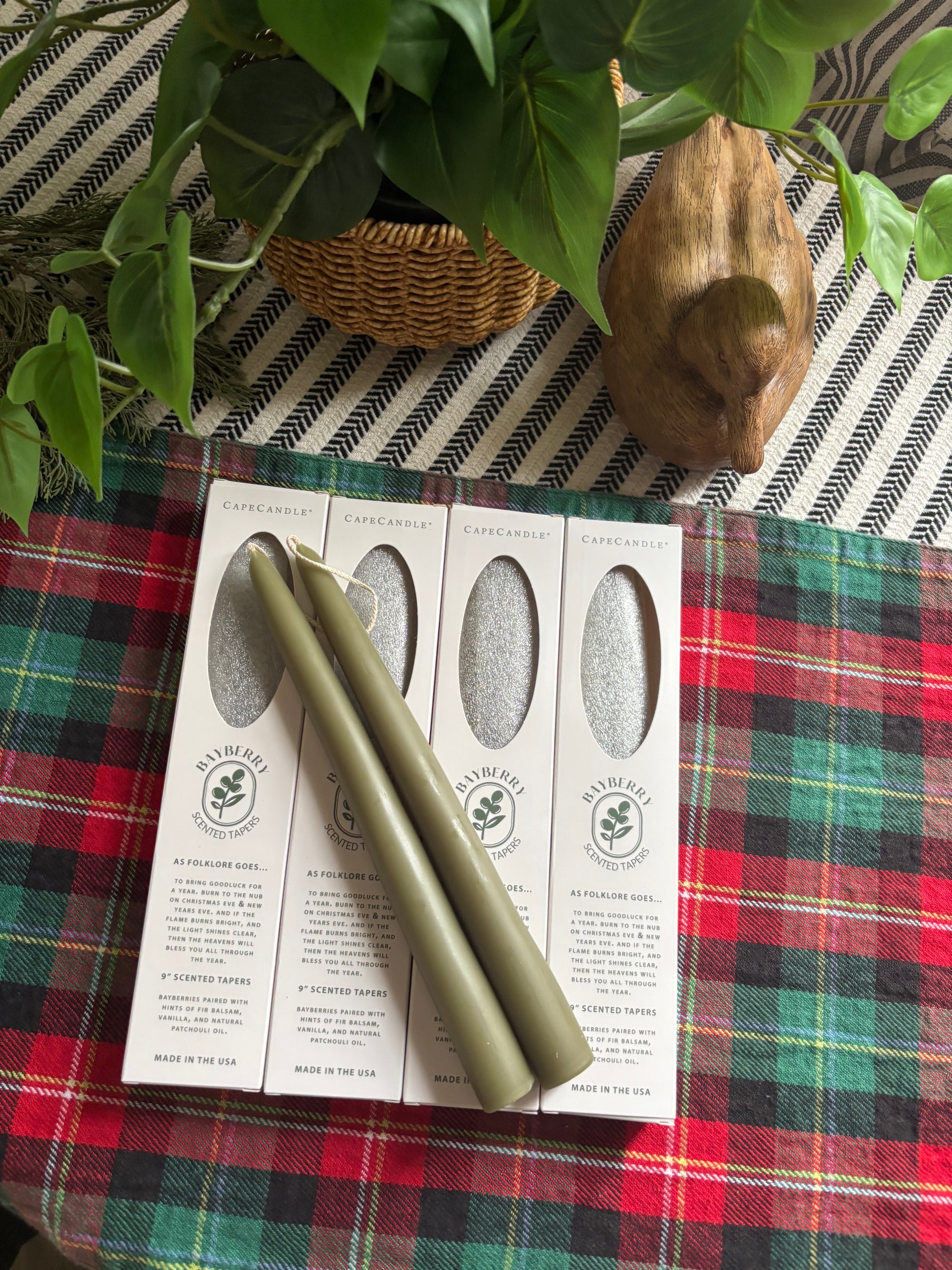 Green rolling pins on a printed paper with a plaid fabric background