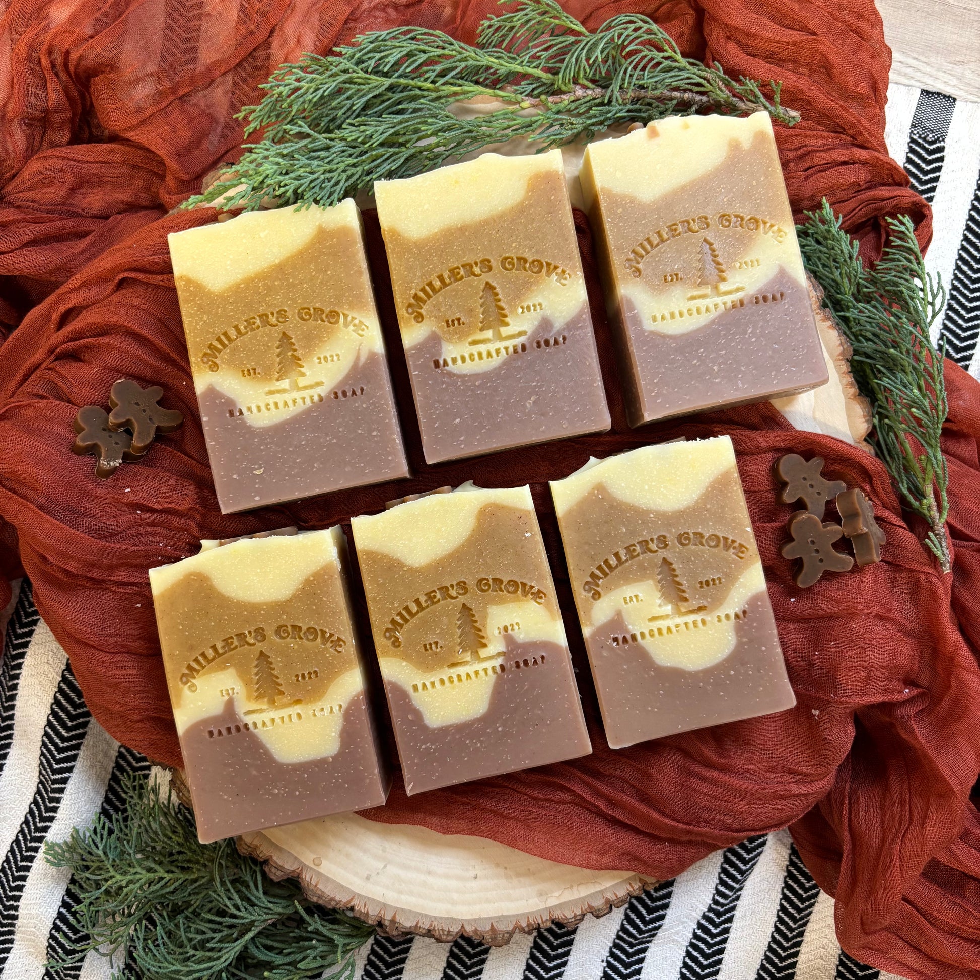 soap bars with a visible brand logo on a decorative surface with greenery.