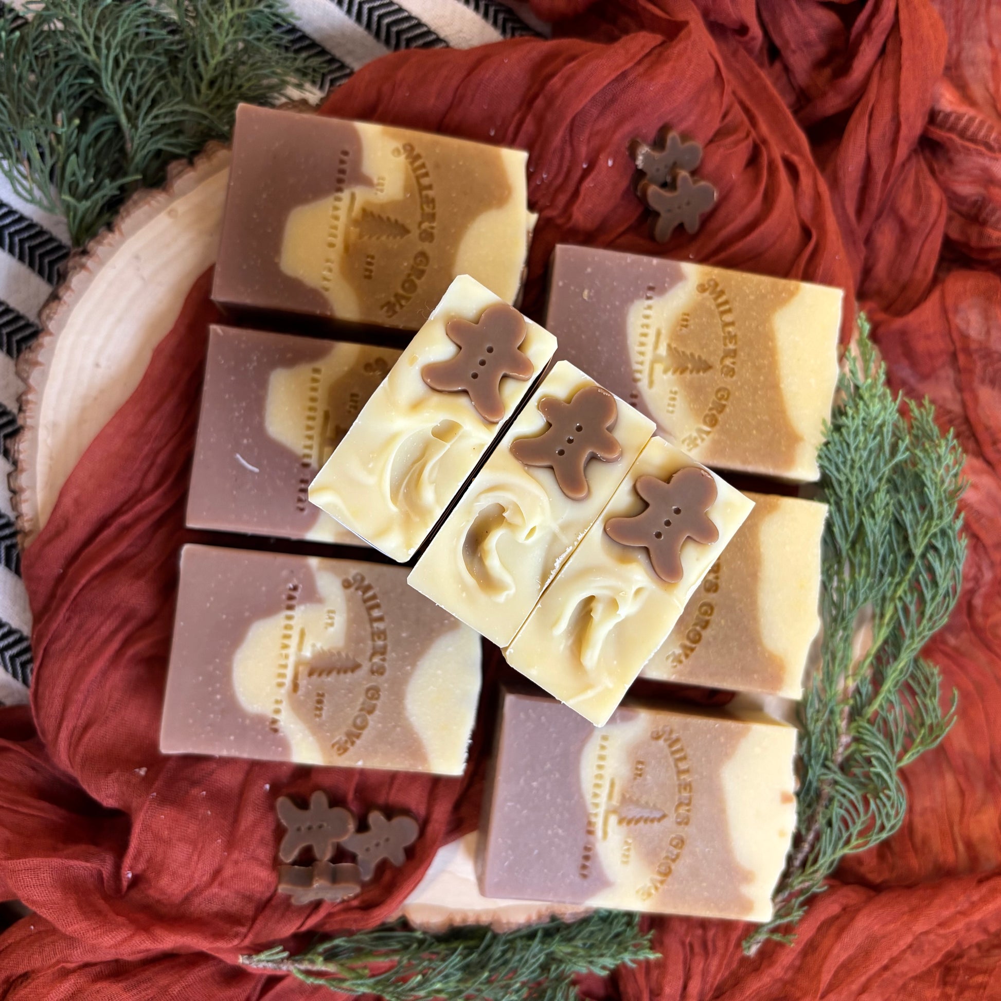 Decorative soap bars with gingerbread men designs on a red fabric background
