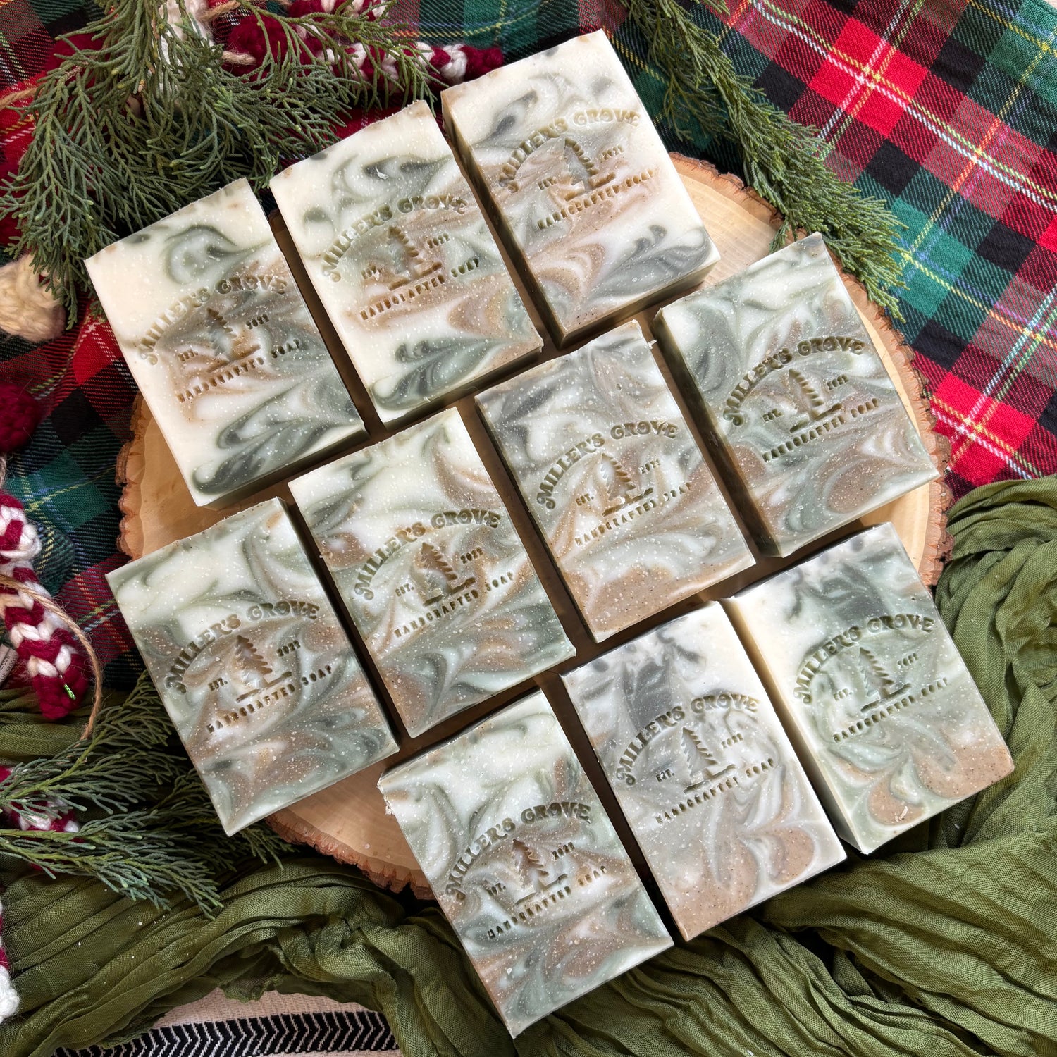 Marble-patterned soap bars on a wooden board with a plaid fabric background