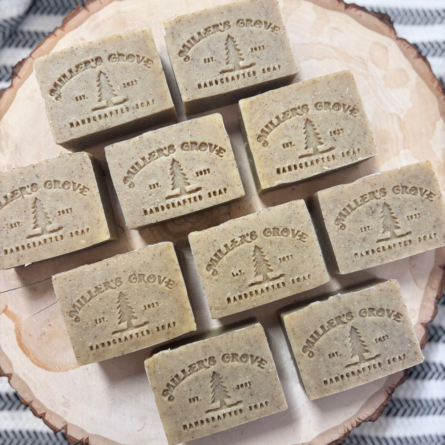Multiple bars of 'Miller's Grove' soap arranged on a wooden surface.
