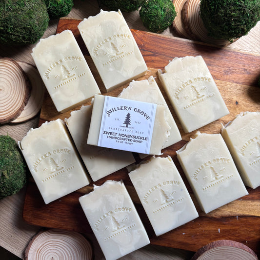 Multiple bars of soap with 'Miller's Grove' branding on a wooden surface with decorative elements.