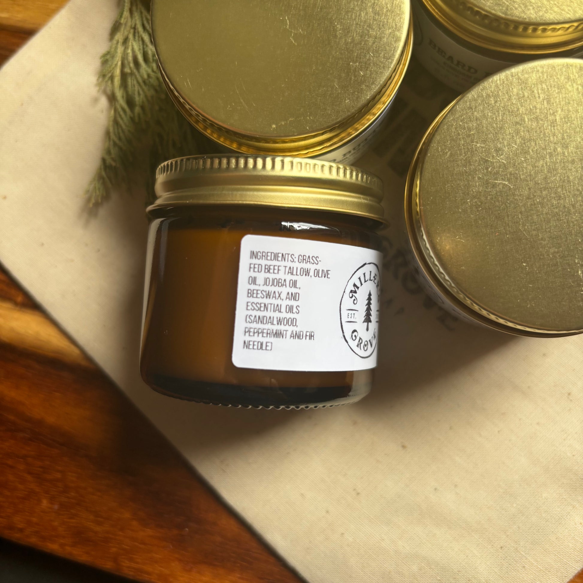 Jar of candle with gold lid on a textured surface