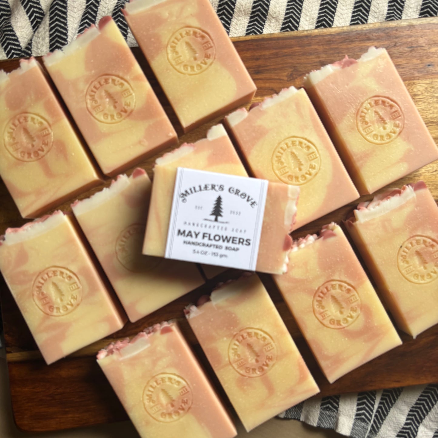 Multiple bars of soap with a central 'Miller's Grove' soap bar on a wooden board.