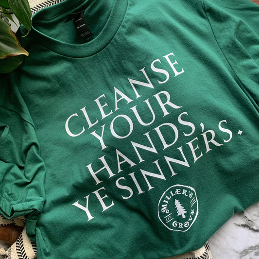Green short sleeve T Shirt that says "Cleanse your hands, ye sinners" on the front