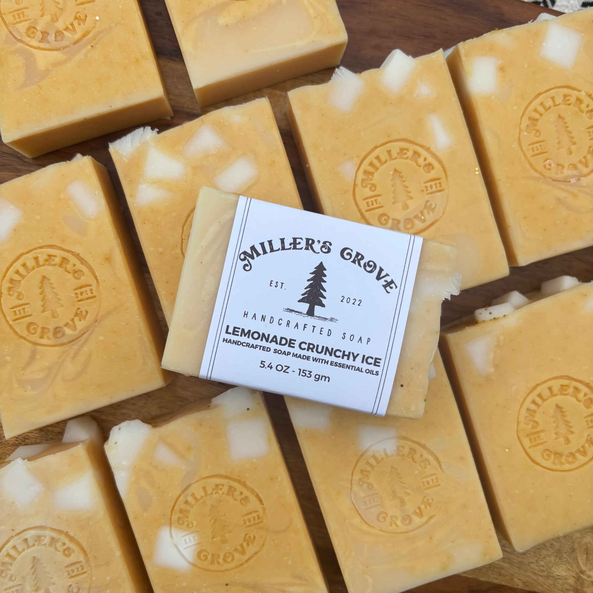 Handcrafted soap bars with a label for Miller's Grove on a wooden surface