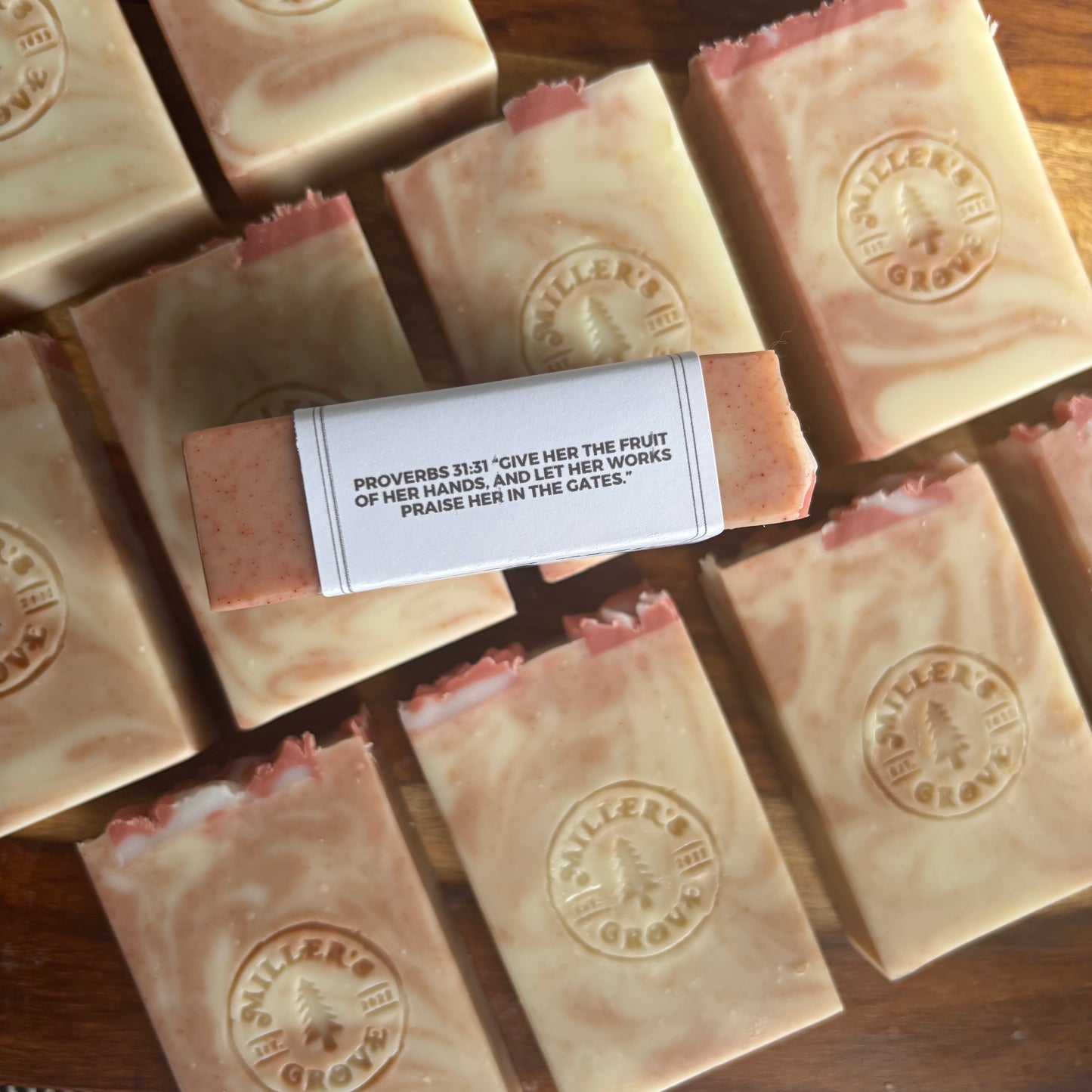 Bars of soap with a visible brand logo on a wooden surface