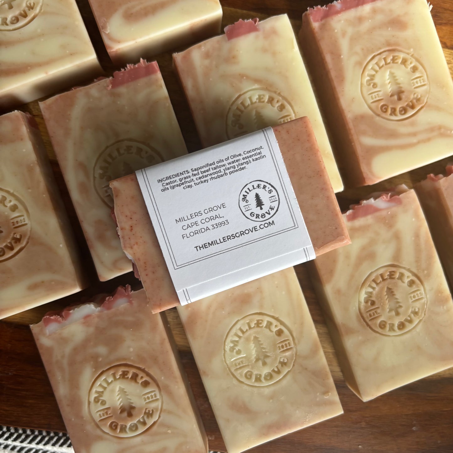 Multiple bars of soap with a visible label on a wooden surface, featuring the 'Miller's Grove' brand.