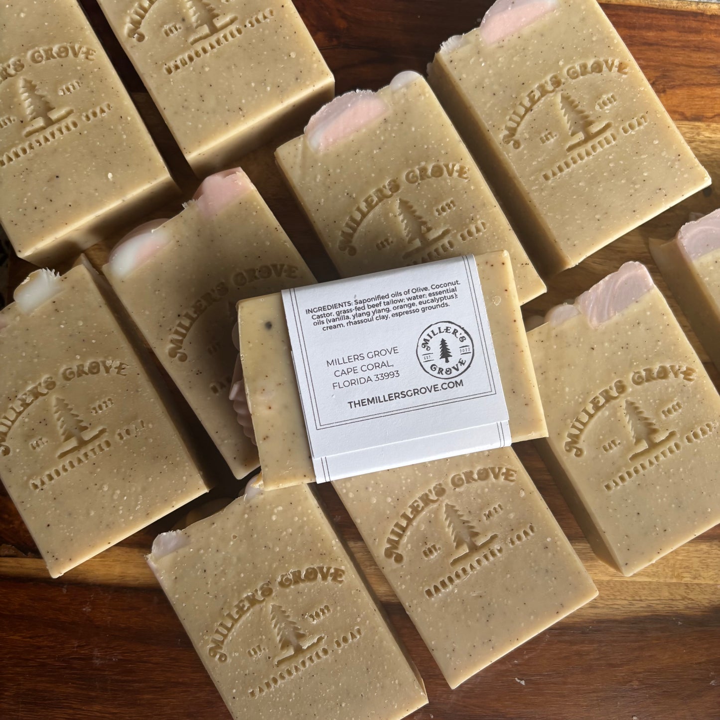 Multiple bars of Miller's Grove soap on a wooden surface with a label in the center.