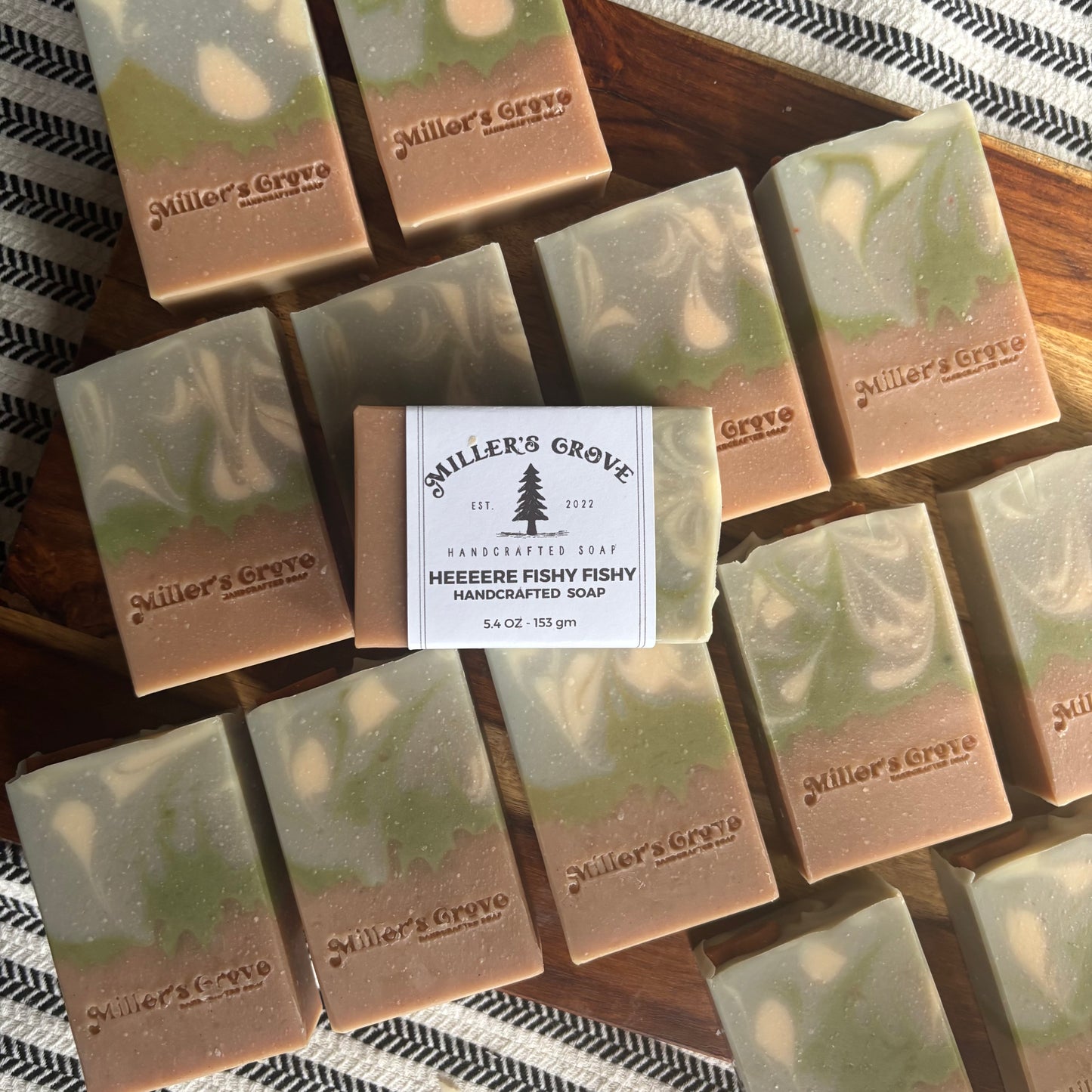 Handcrafted soap bars with 'Miller's Grove' branding on a wooden surface.