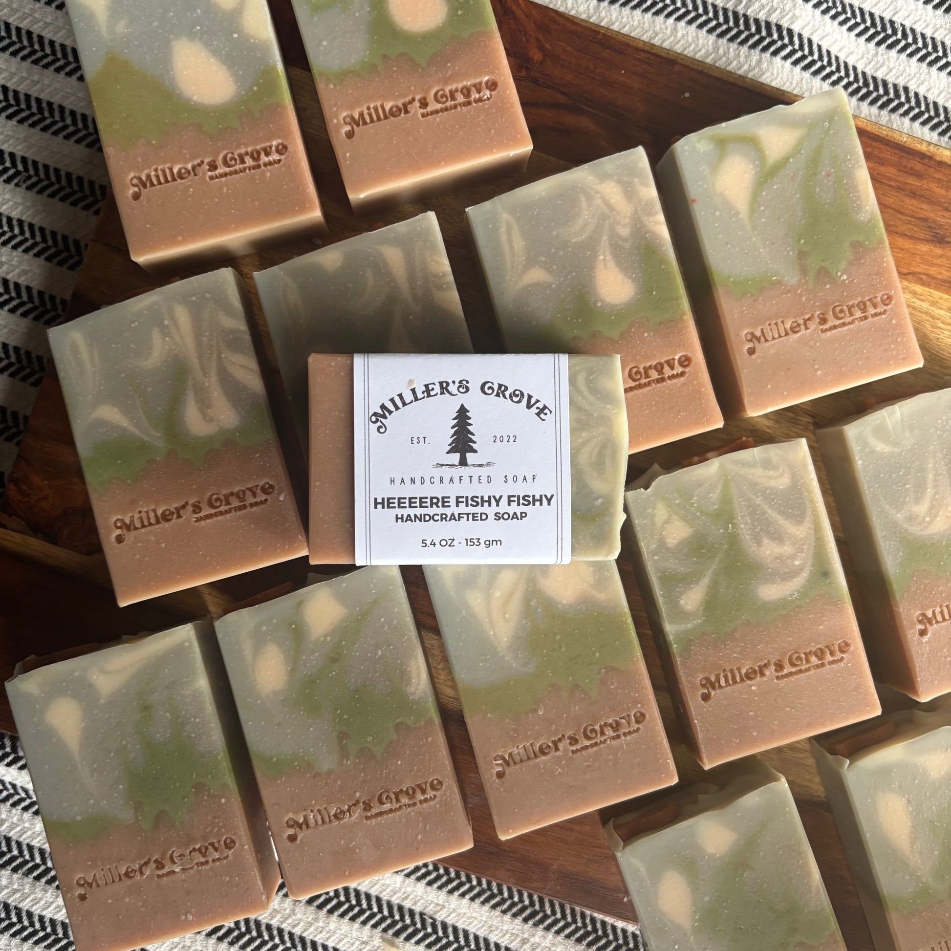 Handcrafted soap bars with 'Miller's Grove' branding on a wooden surface.