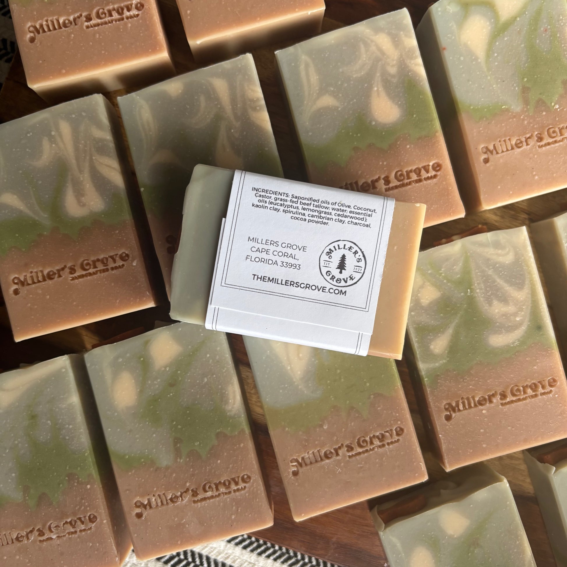 Multiple bars of Miller's Grove soap with a central bar displaying the brand label.