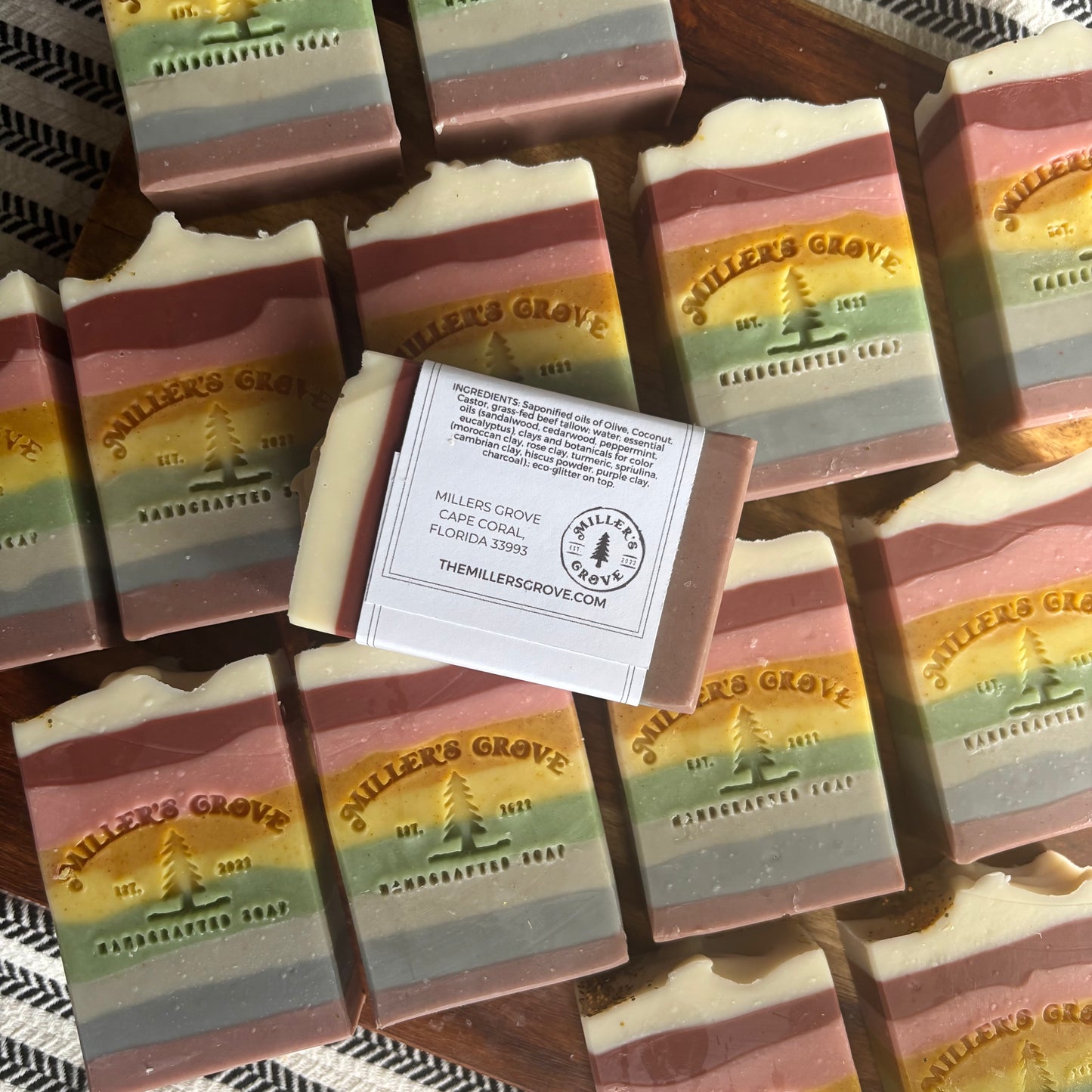 Stack of striped soap bars with 'Miller's Grove' branding on a textured surface.
