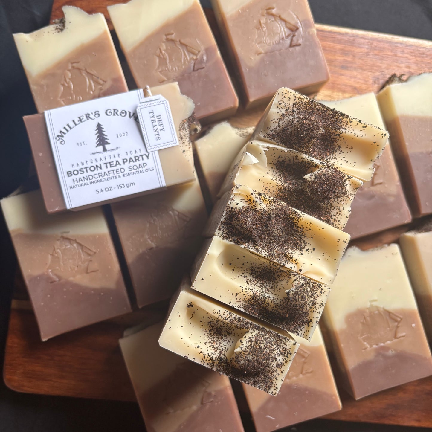 Handcrafted soaps with visible branding on a wooden tray