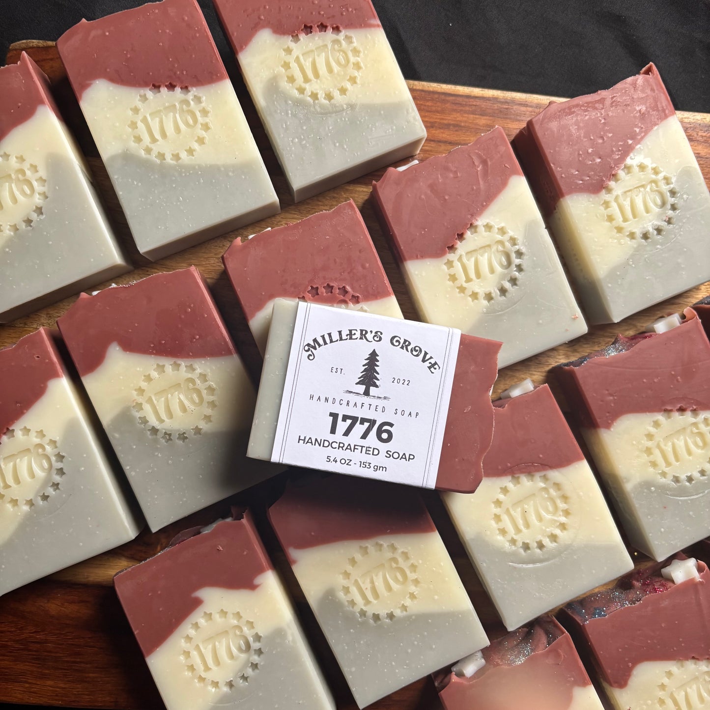 Handcrafted soap bars with a visible brand label on a wooden board