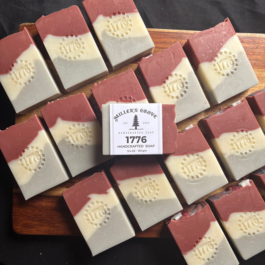 Handcrafted soap bars with a visible brand label on a wooden board.
