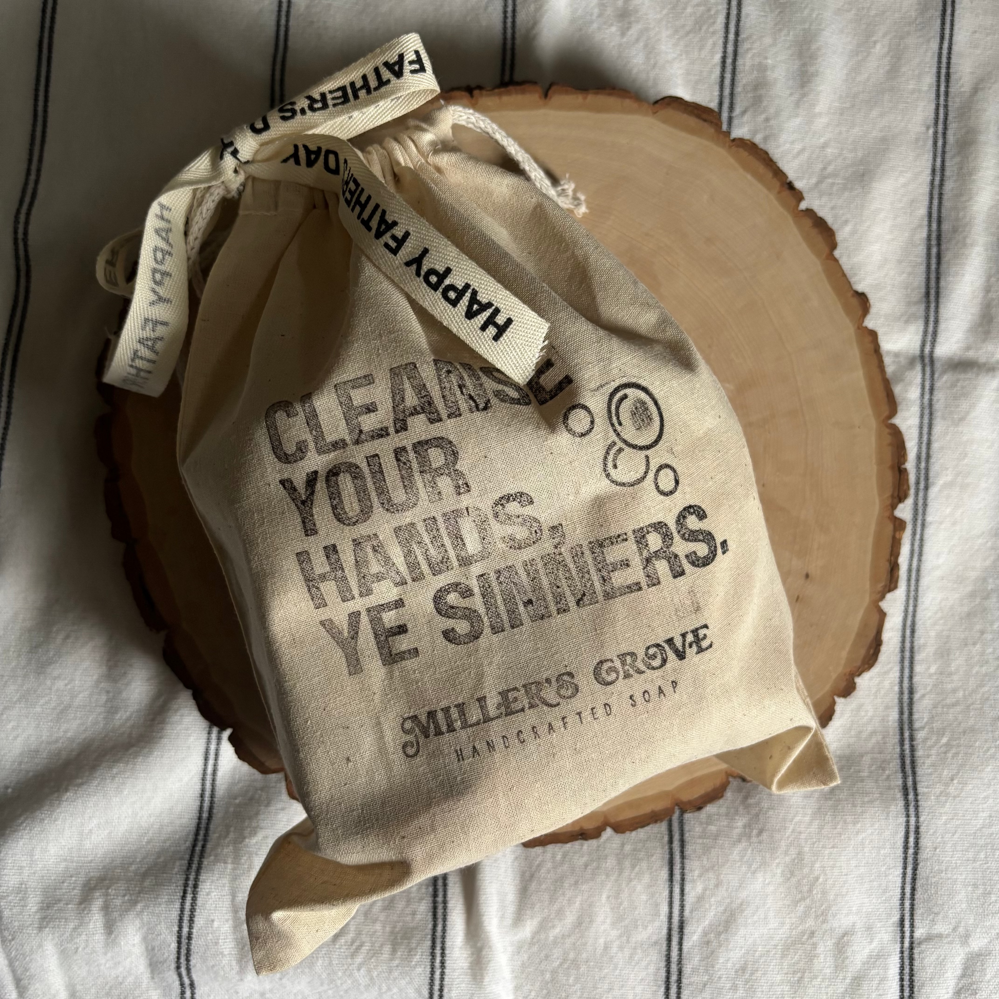 Beige fabric bag with text on a wooden surface